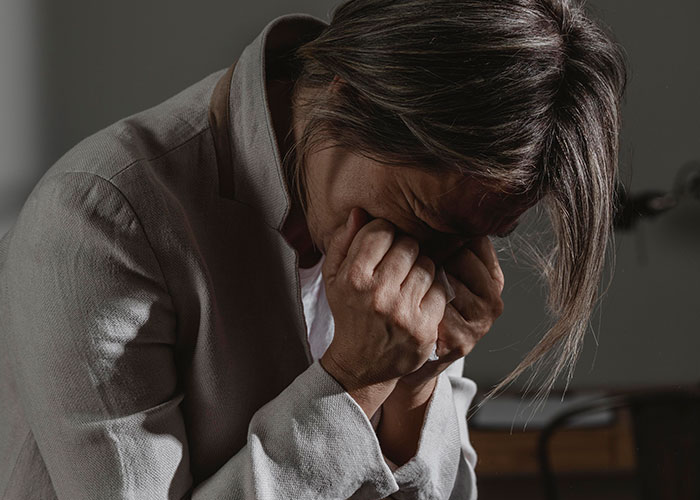 A distressed person holding their face, conveying emotions linked to how to ruin your entire life and real stories online.