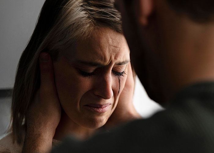 A distressed woman crying while a man comforts her, illustrating the emotional impact of ruining your entire life.