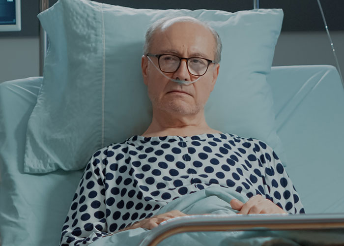 Elderly man in hospital bed with oxygen tube, reflecting on sobering real stories of how to ruin your life.