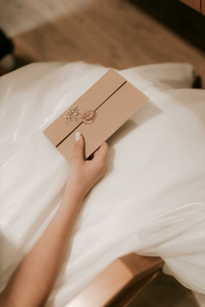 Hand holding a sealed envelope with wax stamp, symbolizing heartbreaking things committed by close friends that broke trust forever.