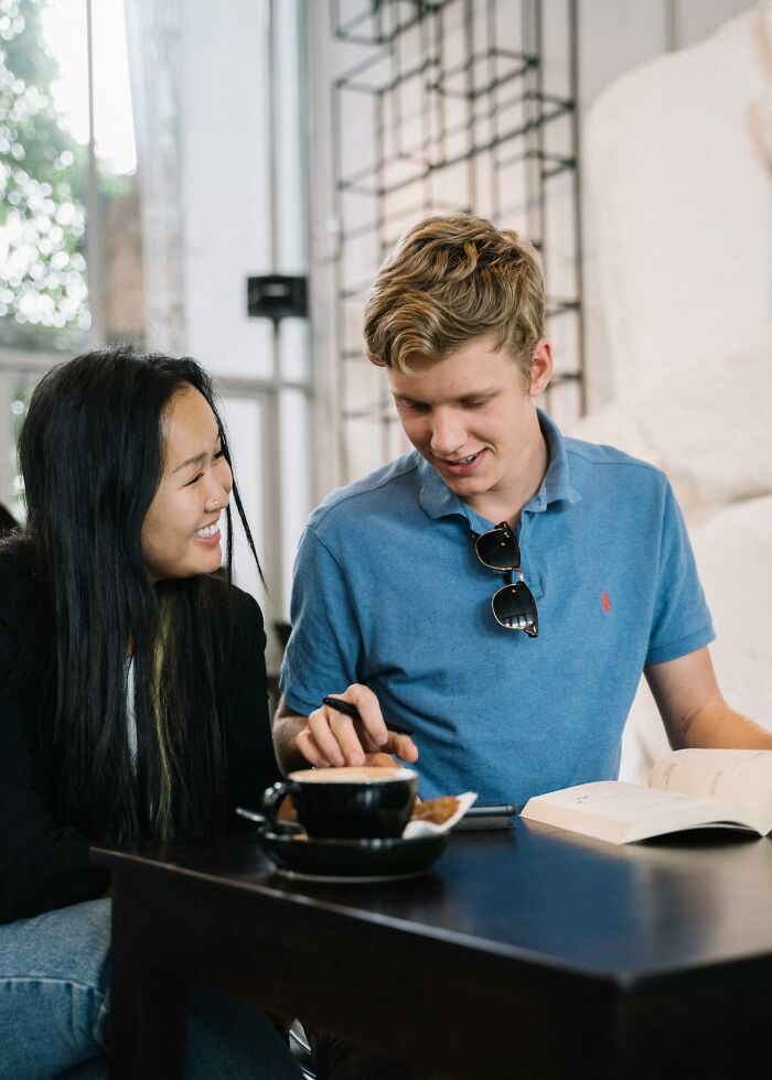 Young man and woman sharing a moment at a café, discussing tips and advice on online dating experience.