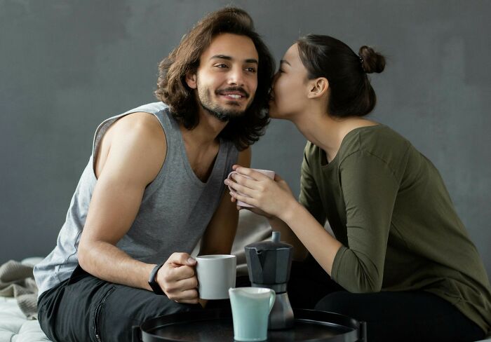 Couple sharing a playful moment while drinking coffee, illustrating themes from savage responses describing your ex as a brand.