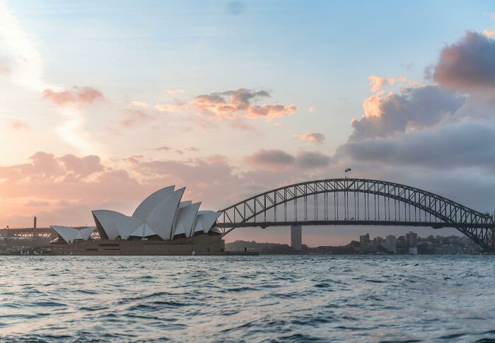 Sydney Opera House and Harbour Bridge at sunrise, symbolizing Aussie identity and citizenship test challenge.