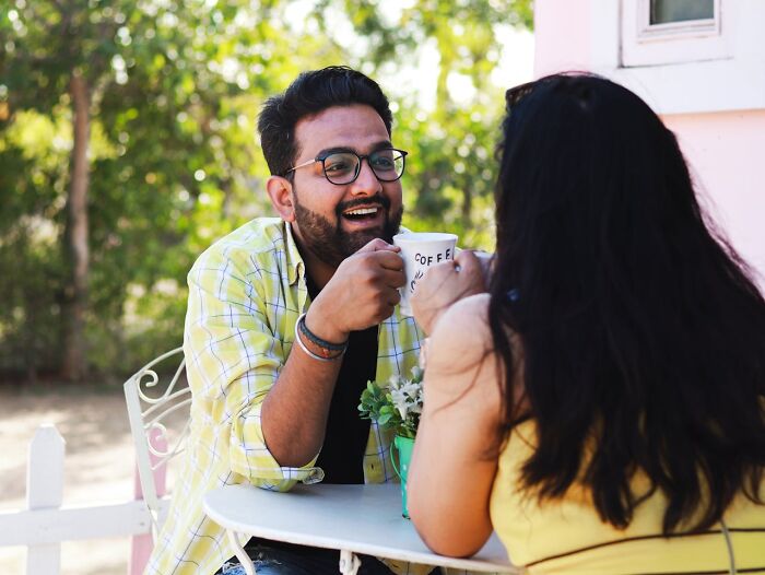 Two people enjoying coffee together outdoors, illustrating disturbing things folks were told that seemed creepy later.