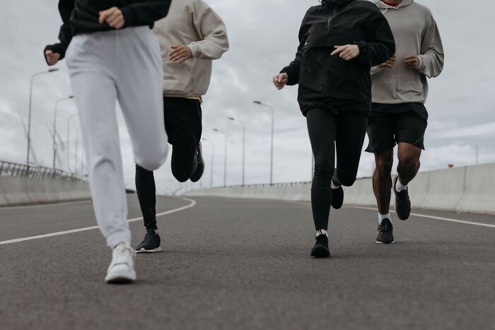 Group of people running outdoors on a cloudy day, symbolizing karma striking with zero mercy in action.