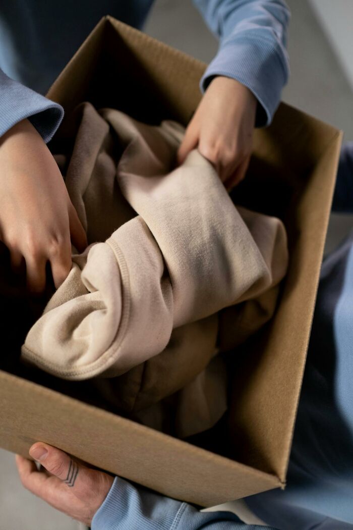 Person folding clothes into a box, representing secrets people are hiding from their partners and keeping forever.