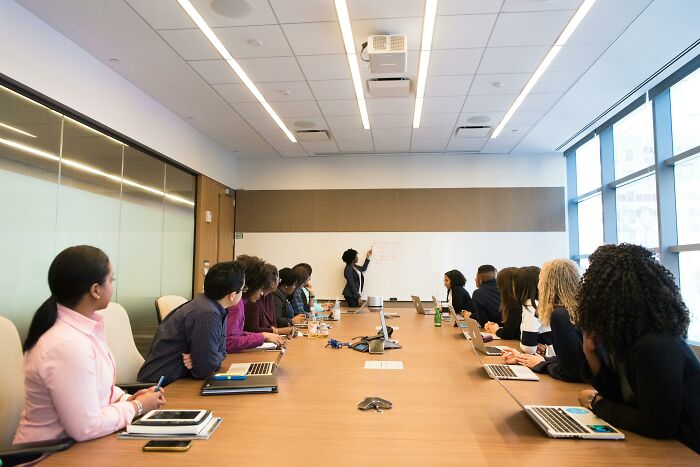 A diverse team in a modern conference room, discussing workplace rules and policies during an office meeting.