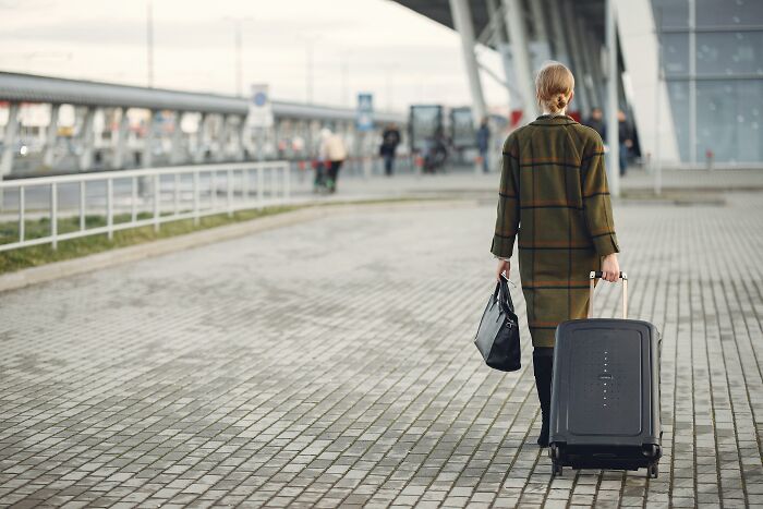 A woman walking away with luggage, symbolizing dramatic breakup stories and chaotic relationship endings.