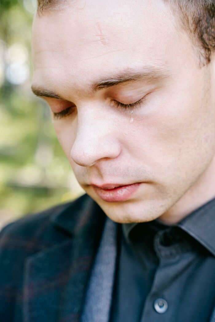 Close-up of a man with a tear on his cheek, showing heartbreak caused by broken trust from close friends.