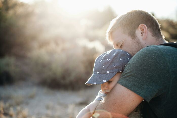 Man hugging a child outdoors, reflecting emotional moments often found in chaotic and dramatic breakup stories.