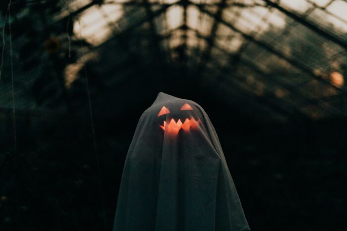 A ghost figure with a glowing jack-o-lantern face in a dark, eerie setting, symbolizing savage internet responses.