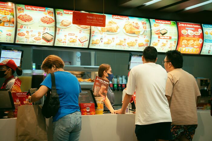 Customers and staff at a fast food counter illustrating hilariously painful moments of misreading social cues.