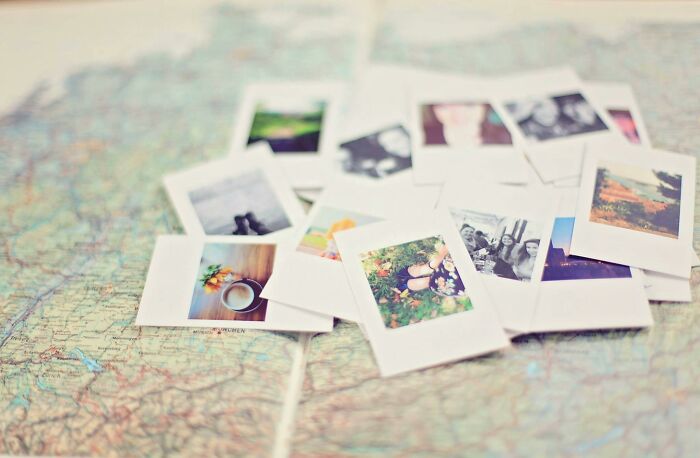 Scattered vintage instant photos on a blurred map background challenging high IQ people to name images perfectly.