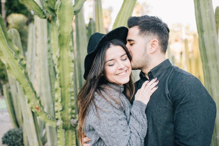 Couple embracing near cactus plants, illustrating secrets people are hiding from their partners in relationships.