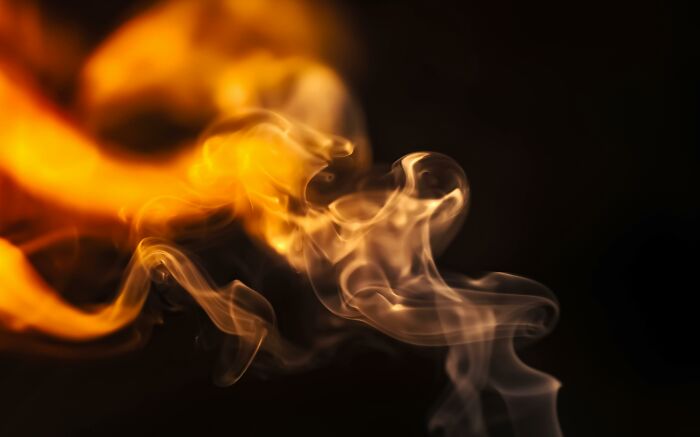Abstract swirling orange and gray smoke against a dark background representing potentially dangerous situations.