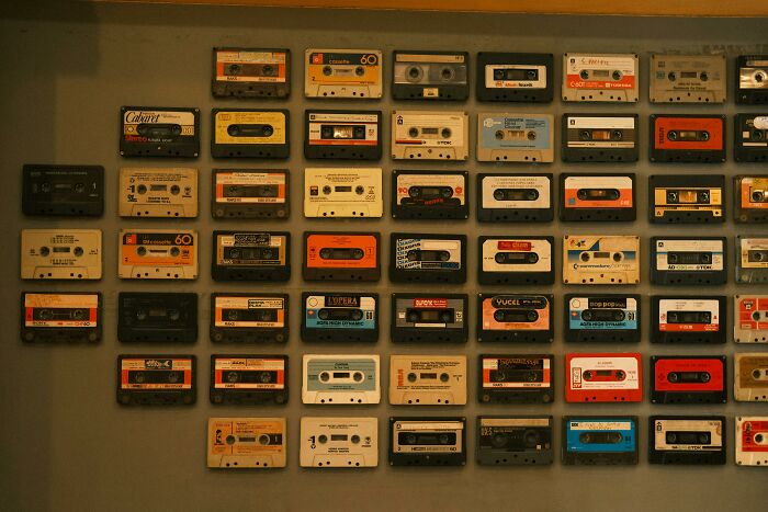 Vintage cassette tapes displayed on a wall, evoking 90s kid pop culture nostalgia and retro music memories.