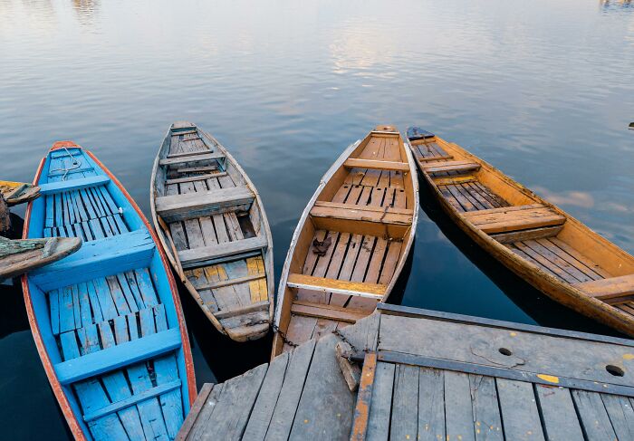 Colorful wooden boats docked on calm water, illustrating unique college courses that you probably never knew existed.