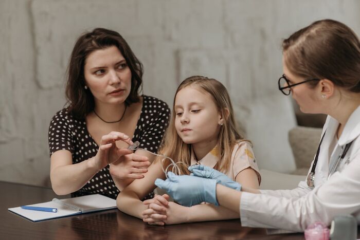 A worried woman and a child receiving a medical treatment, illustrating heartbreaking breach of trust by close friends.