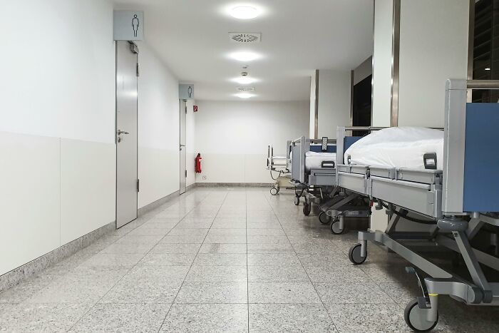 Hospital corridor with empty patient beds along the walls, reflecting chaotic and dramatic breakup stories theme.