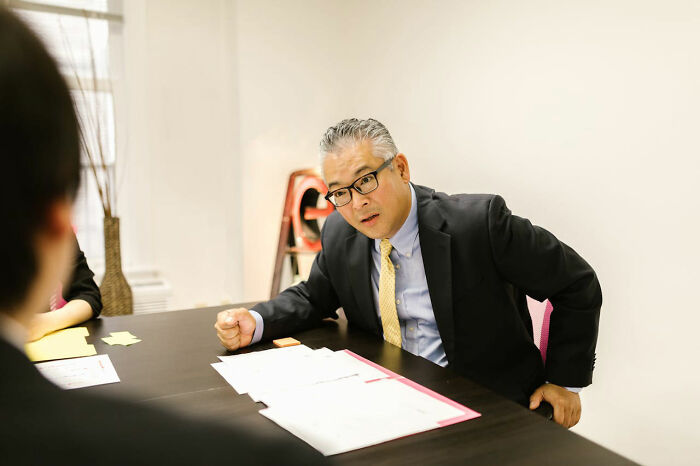 Man in suit and glasses showing disappointment during a meeting, illustrating times people were disappointed in someone they idolized.