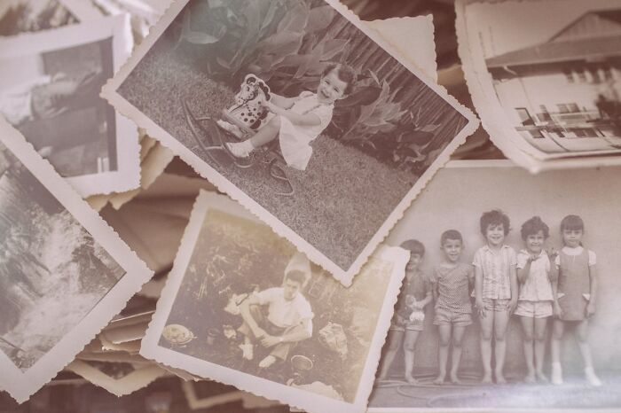 A pile of vintage black and white photos showing children, evoking nostalgia for advice on online dating experience.