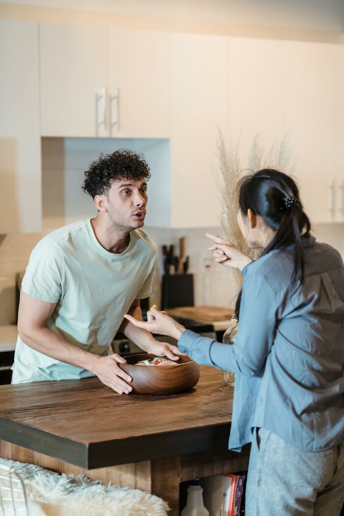 Couple having a tense argument in kitchen showing first signs that scream someone is having an affair.