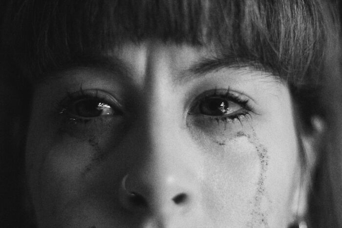 Close-up of a woman with tear-streaked face reflecting the pain of chaotic and dramatic breakup stories.