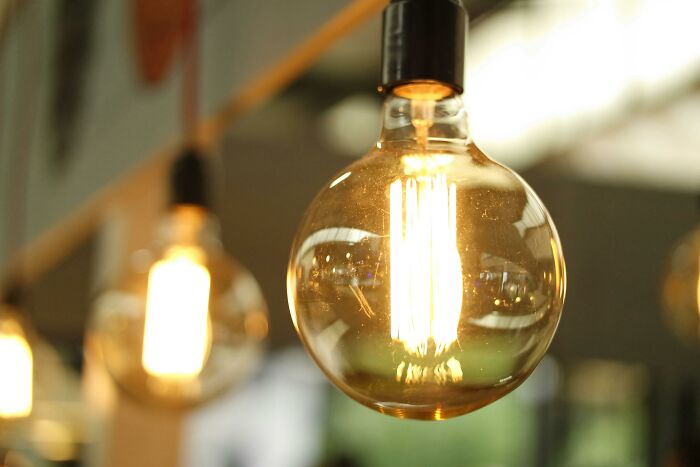 Close-up of a glowing light bulb in a modern setting, symbolizing chaotic and dramatic breakup stories shared by people.