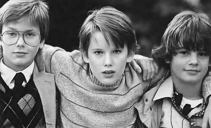 Three young boys posing together in a black and white photo representing people who left a mark in movie and music industries.