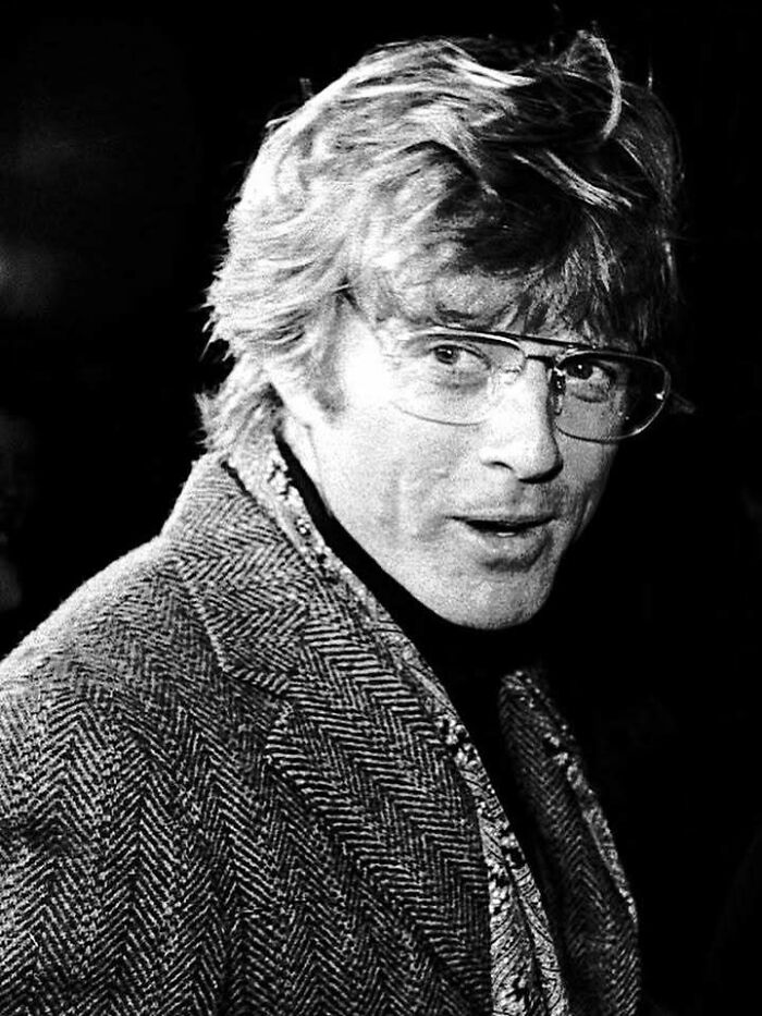 Black and white portrait of a man with glasses and textured jacket, symbolizing people who left a mark in movie and music industries.