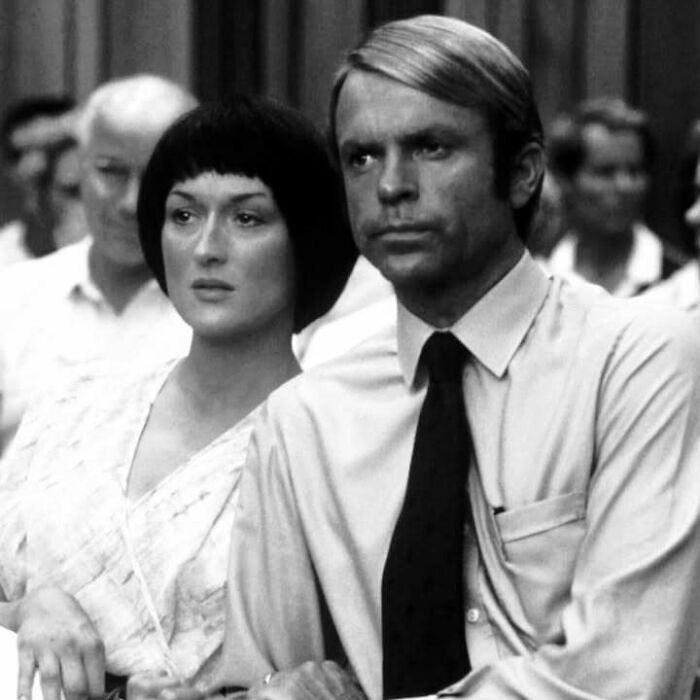 Black and white photo of two serious people at an event, highlighting figures who left a mark in movie and music industries.