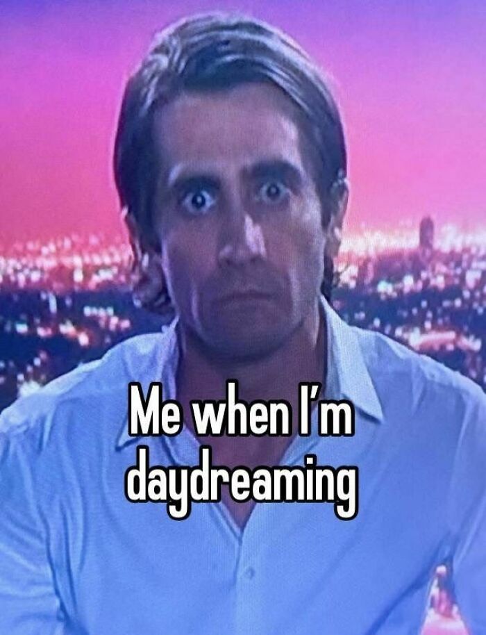 Man with wide eyes staring intensely at the camera, representing evil thoughts while daydreaming in a nighttime cityscape background.