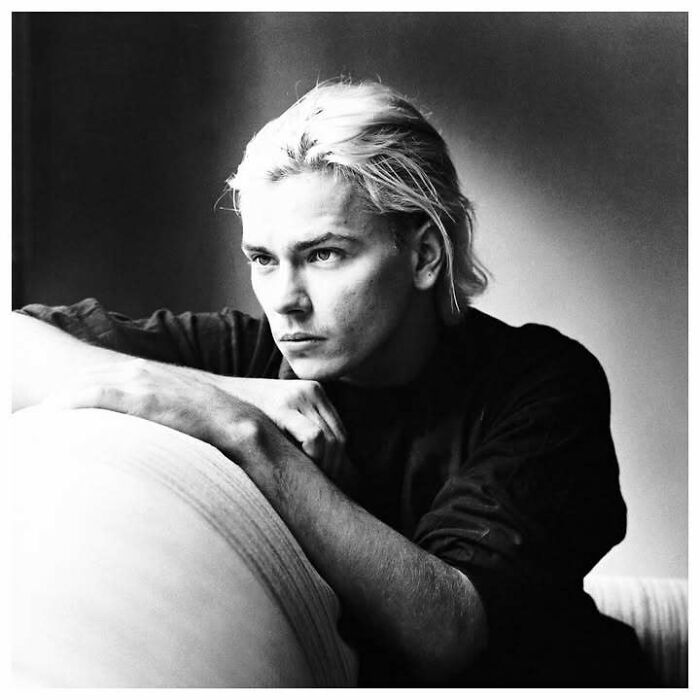 Young man with blonde hair in a black shirt, posing thoughtfully, representing people who left a mark in movie and music industries.