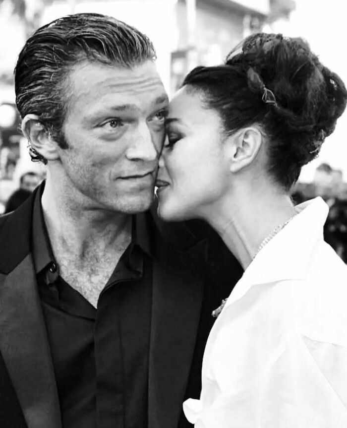 Black and white close-up of two people sharing a tender moment, highlighting stories of impact in movie and music industries.