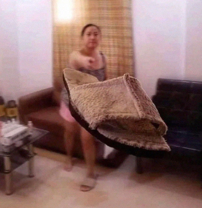 Woman mid-throw of a slipper in a living room, captured in a hilarious photo before disaster struck unexpectedly.