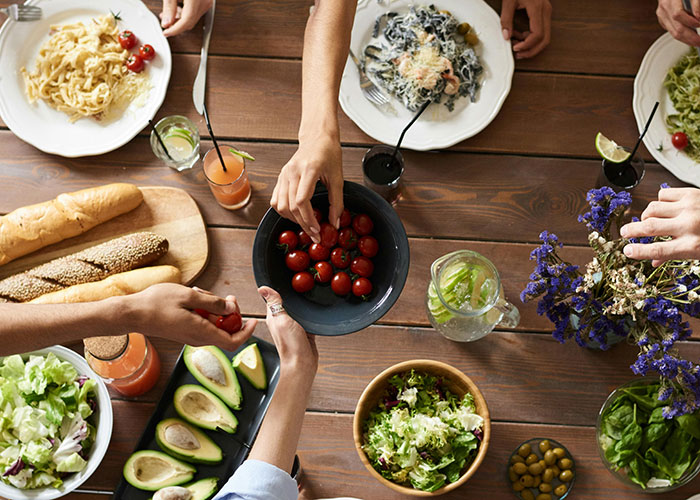 Family sharing healthy food at the table, symbolizing man prepared to fight for stepson&rsquo;s diet change against mom&rsquo;s wishes