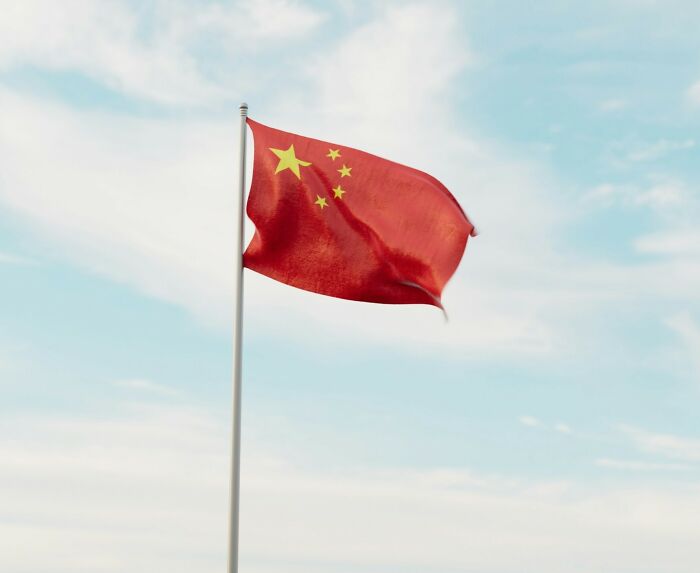 Chinese flag waving against blue sky representing TV star facing capital punishment in China over illegal substances. Chinese flag waving against blue sky representing TV star facing capital punishment in China over illegal substances.