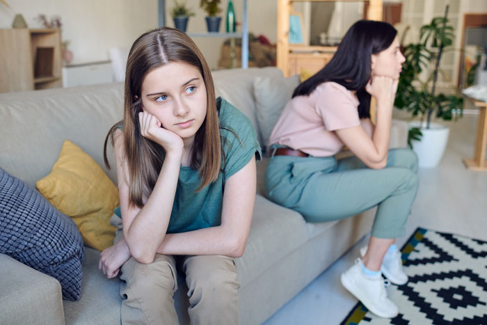 Two women sitting on a couch looking upset, illustrating conflict over grandma&rsquo;s leather shoes and vegan sister wearing them.