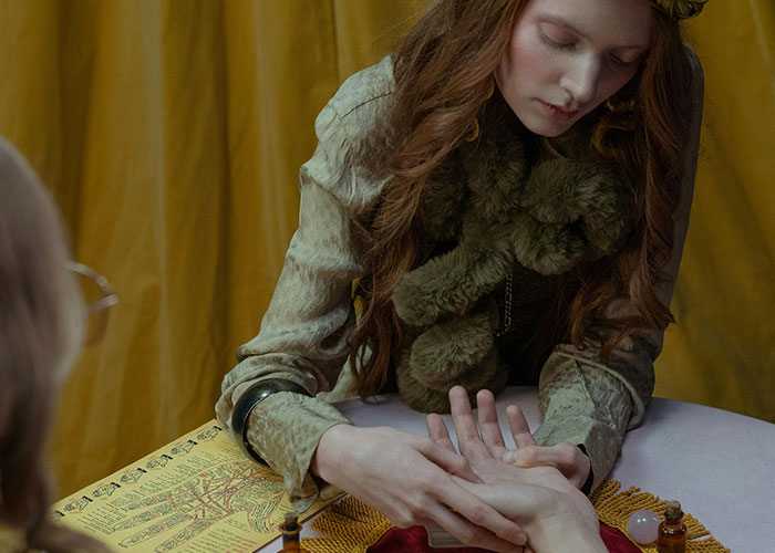 Psychic reading session with a woman examining palm lines, revealing truths told by a psychic coming true.