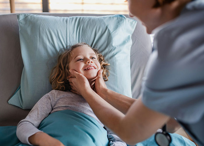 Child smiling in bed while being comforted by an adult during a psychic reading that came true moment.