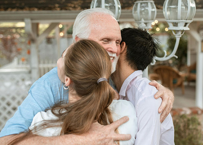 Three people sharing a warm group hug outdoors, illustrating moments people were told by a psychic and it came true.