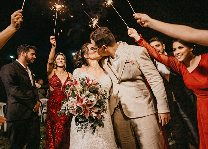 Couple kissing at wedding surrounded by friends holding sparklers, celebrating a psychic prediction that came true.