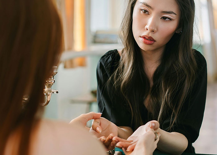 Woman in black shirt reading palm of another person during a psychic session focused on accurate predictions coming true.