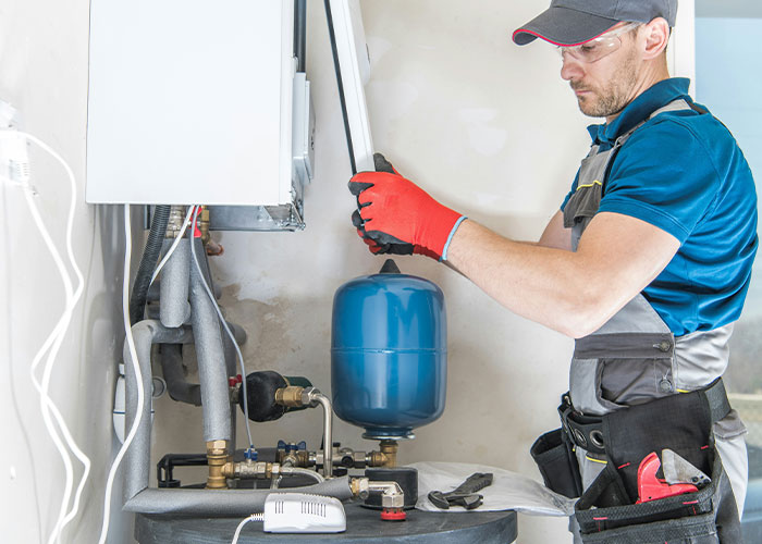 Man in work gloves and safety glasses fixing a home boiler system, illustrating psychic predictions that came true.