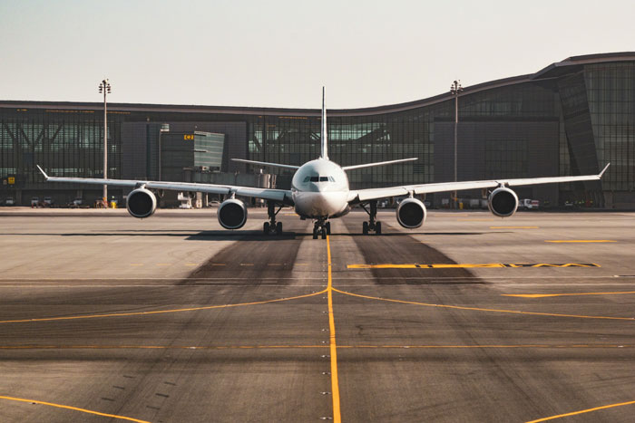 Commercial airplane taxiing on runway at airport terminal, illustrating rude family trying to bully lady from plane seat.