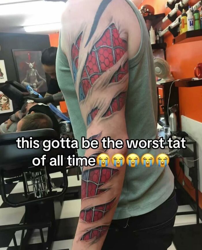 Tattoo artist working in a shop with a colorful arm tattoo and humorous text about worst tattoos in occult pleasures context.