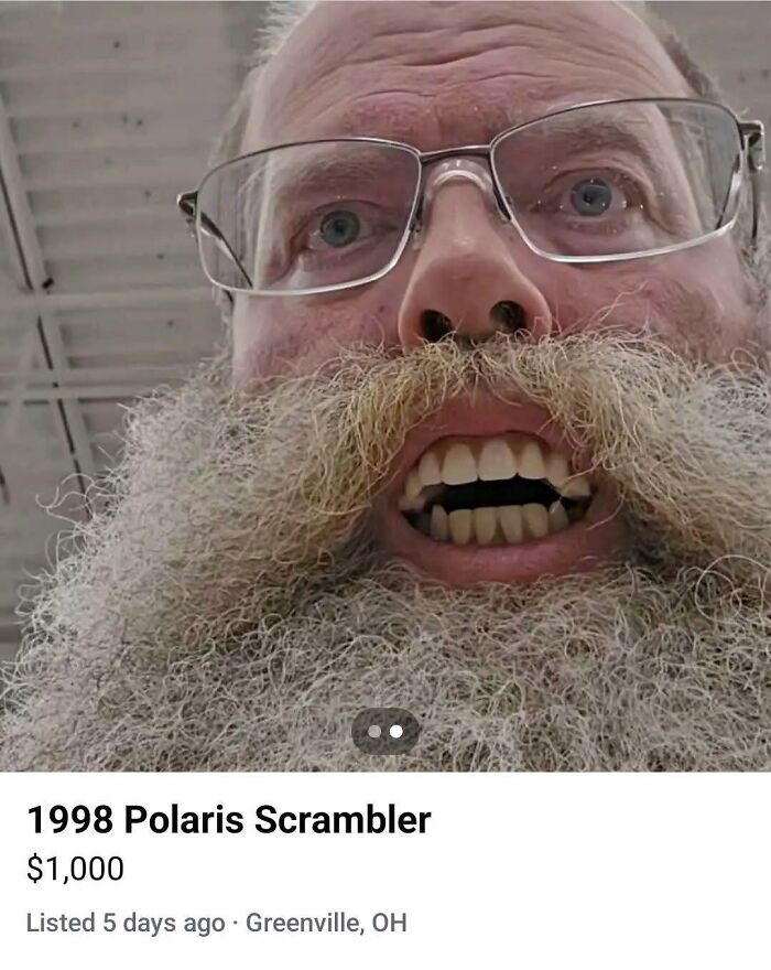 Close-up of a man with glasses and a large beard making a funny face, fitting the pleasures of the occult humor theme.