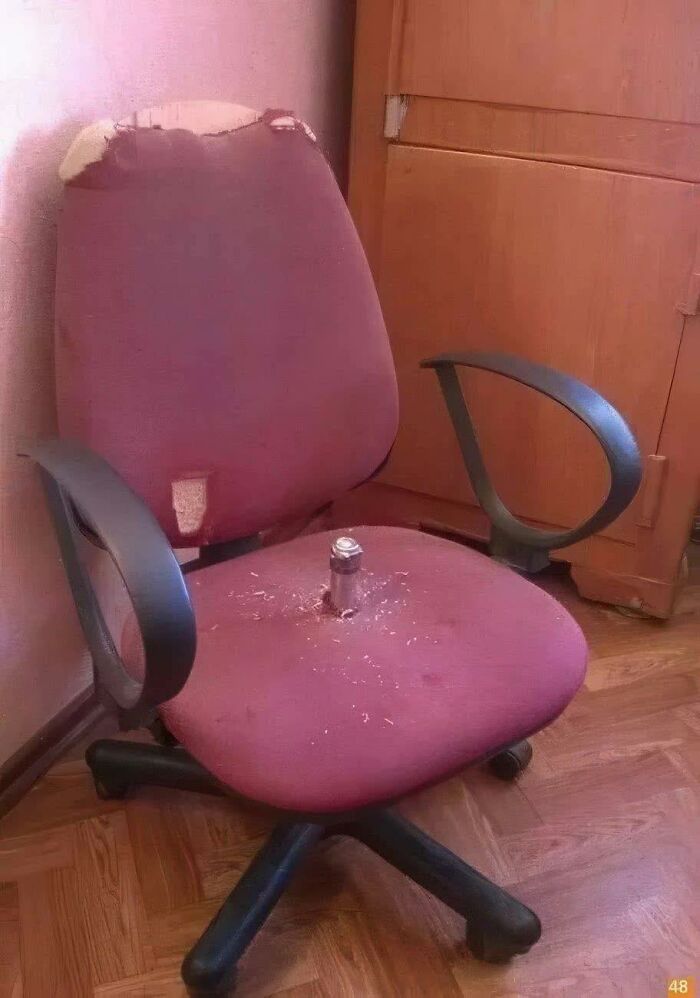 Worn-out office chair with torn fabric and a metal bolt protruding from the seat, showing pleasures of the occult humor.