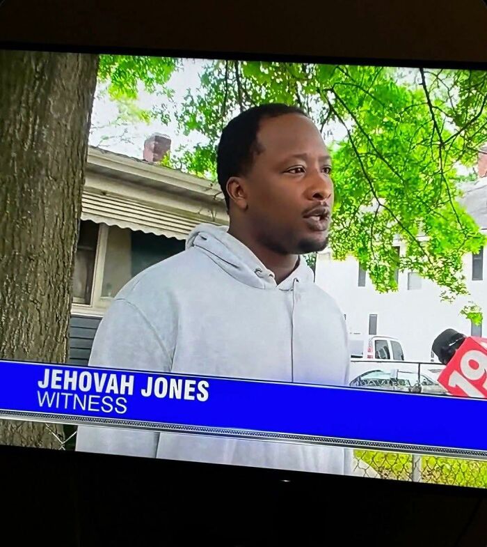 Man named Jehovah Jones giving an outdoor interview near trees and houses, a humorous out of context moment for occult pleasures.