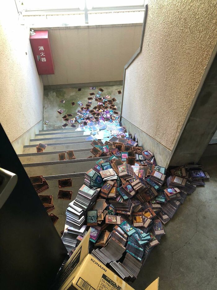 Pile of occult-themed trading cards scattered across a stairwell, creating a chaotic and humorous scene.